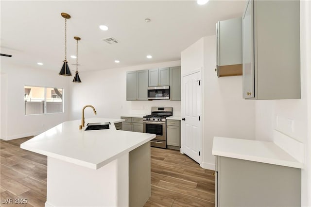 4779 Straight Flush Dr Unit 103, Las Vegas, NV 89122 - kitchen with appliances with stainless steel finishes, a sink, gray cabinets, light wood-style floors, and recessed lighting