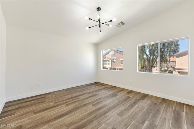 4779 Straight Flush Dr Unit 103, Las Vegas, NV 89122 - empty room featuring a chandelier, wood finished floors, vaulted ceiling, and baseboards