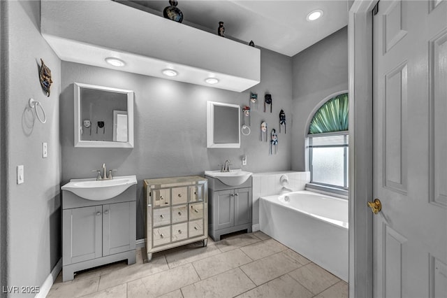 4005 Poppy Fields Dr, Las Vegas, NV 89129 - full bathroom featuring a bath, two vanities, tile patterned floors, and baseboards