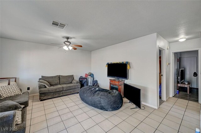 4 Britz Cir, North Las Vegas, NV 89030 - living room featuring ceiling fan, light tile patterned floors, baseboards, and a textured ceiling