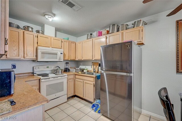 4 Britz Cir, North Las Vegas, NV 89030 - kitchen featuring white appliances, a sink, light brown cabinets, light countertops, and light tile patterned floors