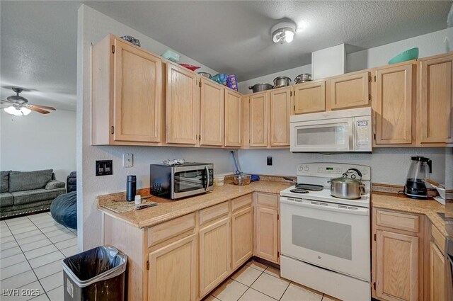 4 Britz Cir, North Las Vegas, NV 89030 - kitchen featuring white appliances, light brown cabinetry, light tile patterned floors, light countertops, and ceiling fan