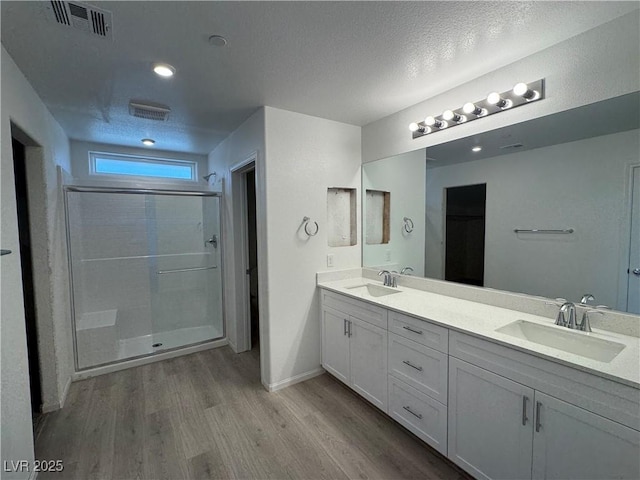 5163 Capucina St Lot 3, Las Vegas, NV 89122 - bathroom featuring wood finished floors, a stall shower, double vanity, and baseboards