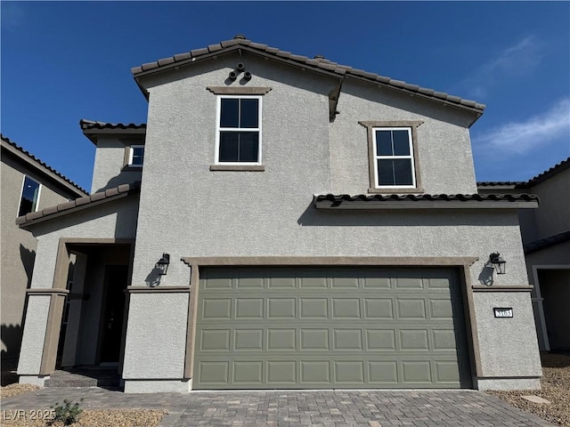 5163 Capucina St Lot 3, Las Vegas, NV 89122 - view of front of house with stucco siding, a tile roof, an attached garage, and decorative driveway