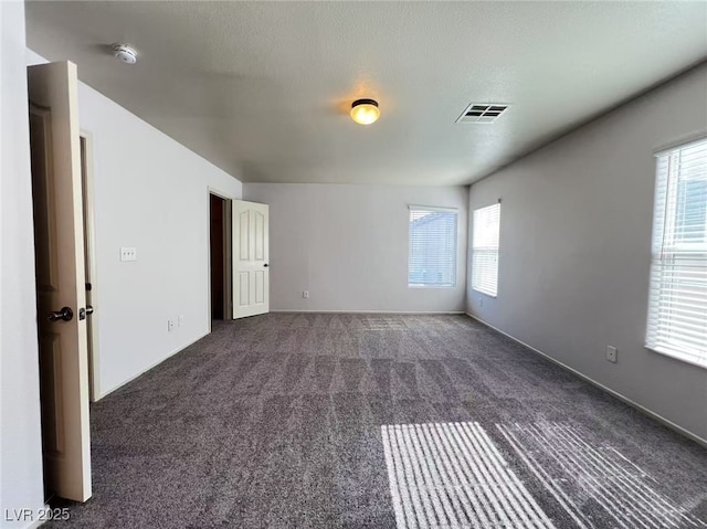 7249 Old Glory St, Las Vegas, NV 89148 - empty room with dark colored carpet, healthy amount of natural light, a smoke detector, and baseboards