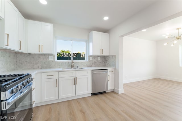 2180 Palora Ave, Las Vegas, NV 89169 - kitchen with stainless steel appliances, a sink, light countertops, decorative backsplash, and light wood finished floors