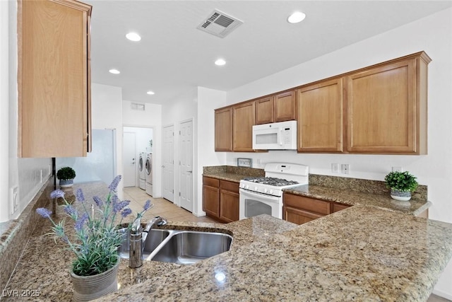7448 Lintwhite St, North Las Vegas, NV 89084 - kitchen featuring white appliances, washer and clothes dryer, a sink, stone countertops, and brown cabinets