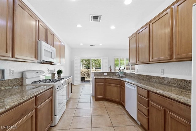 7448 Lintwhite St, North Las Vegas, NV 89084 - kitchen featuring white appliances, recessed lighting, light tile patterned flooring, a peninsula, and dark stone countertops