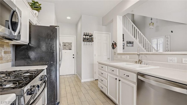 482 Painted Sage Ct, Henderson, NV 89015 - kitchen with stainless steel appliances, a sink, white cabinetry, tasteful backsplash, and light countertops