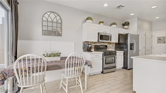 482 Painted Sage Ct, Henderson, NV 89015 - kitchen featuring stainless steel appliances, white cabinets, wainscoting, decorative backsplash, and recessed lighting