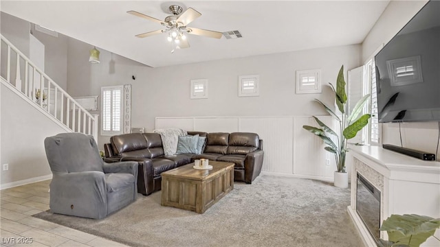 482 Painted Sage Ct, Henderson, NV 89015 - living area featuring stairs, healthy amount of natural light, ceiling fan, a glass covered fireplace, and a wainscoted wall