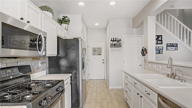 482 Painted Sage Ct, Henderson, NV 89015 - kitchen with appliances with stainless steel finishes, a sink, white cabinets, backsplash, and recessed lighting