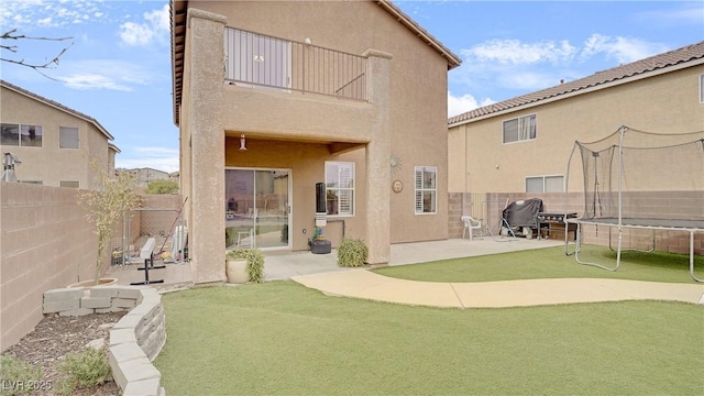 482 Painted Sage Ct, Henderson, NV 89015 - back of house featuring a trampoline, a fenced backyard, a patio area, and stucco siding