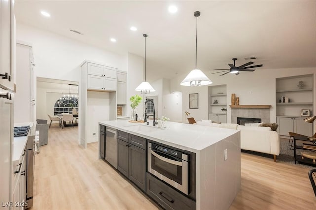 4016 Tyler William Ln, Las Vegas, NV 89130 - kitchen with a sink, dishwasher, ceiling fan, light wood-style floors, and a tile fireplace