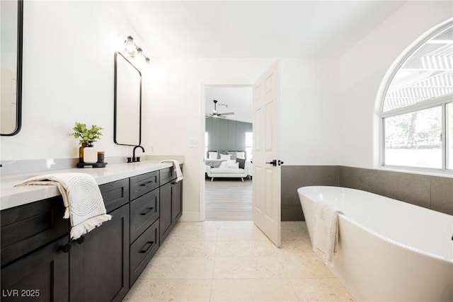 4016 Tyler William Ln, Las Vegas, NV 89130 - ensuite bathroom featuring double vanity, a freestanding bath, a ceiling fan, and tile patterned flooring