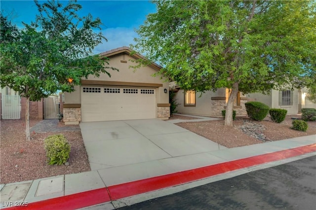 8128 Devils Canyon St, North Las Vegas, NV 89085 - view of front of home featuring stucco siding, a garage, stone siding, concrete driveway, and a gate