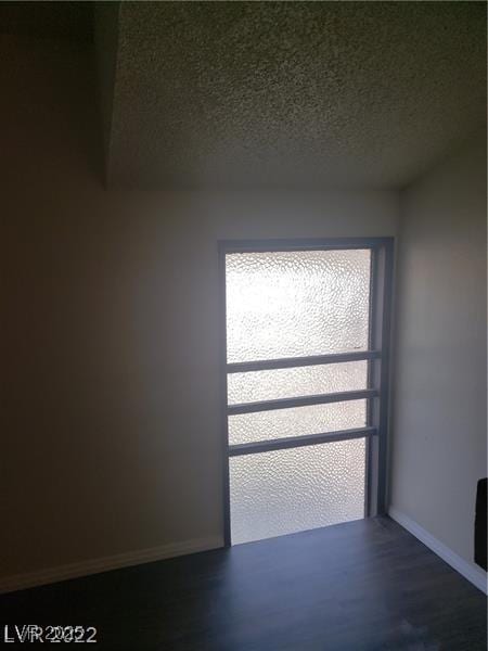 4770 Topaz St Unit 79, Las Vegas, NV 89121 - spare room featuring baseboards, dark wood-type flooring, and a textured ceiling