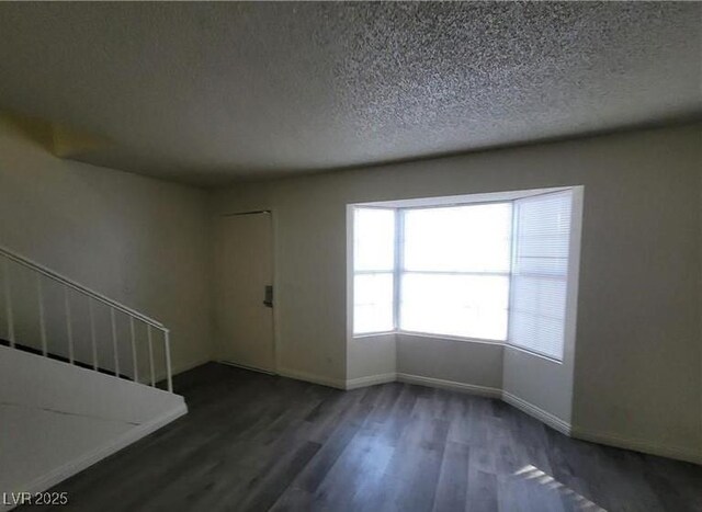 854 Stainglass Ln, Las Vegas, NV 89110 - spare room featuring wood finished floors, baseboards, and a textured ceiling