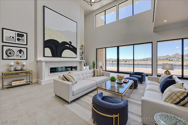 1600 Pleasant Bay Ct, Henderson, NV 89011 - living area featuring a towering ceiling, a water view, tile patterned floors, and baseboards