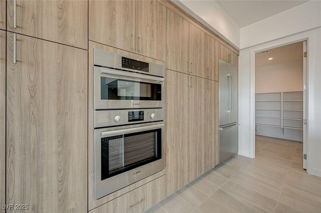 1600 Pleasant Bay Ct, Henderson, NV 89011 - kitchen with light brown cabinetry, stainless steel appliances, modern cabinets, and light tile patterned floors