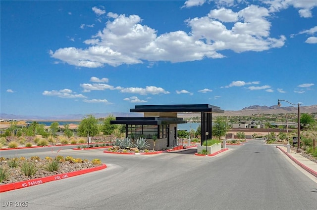 1600 Pleasant Bay Ct, Henderson, NV 89011 - view of asphalt road with a mountain view, curbs, a gated entry, and street lights