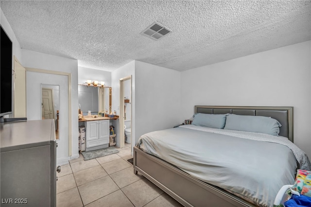 54 Del Amo Dr, Las Vegas, NV 89110 - bedroom with light tile patterned flooring, a textured ceiling, a chandelier, and ensuite bathroom