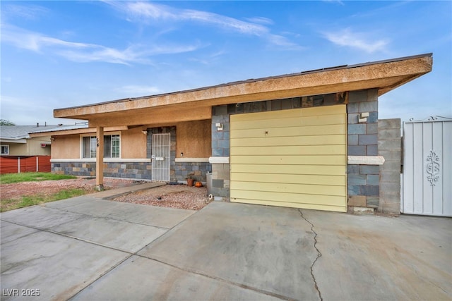 54 Del Amo Dr, Las Vegas, NV 89110 - view of front of house featuring a garage, stone siding, and concrete driveway