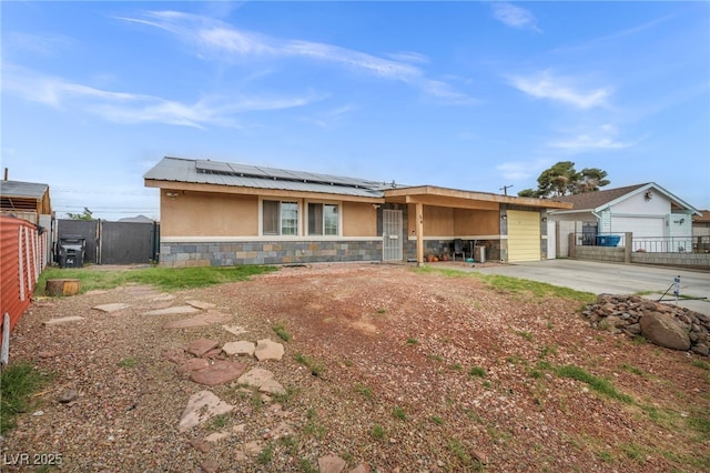 54 Del Amo Dr, Las Vegas, NV 89110 - view of front of house with stone siding, solar panels, stucco siding, a garage, and driveway