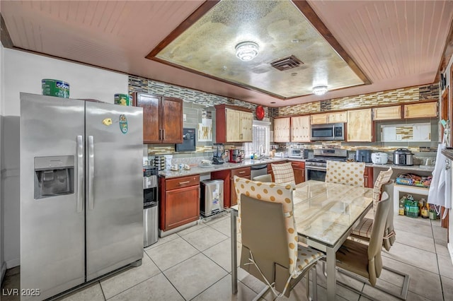 54 Del Amo Dr, Las Vegas, NV 89110 - kitchen with stainless steel appliances, a raised ceiling, light countertops, a sink, and light tile patterned floors