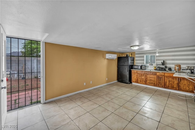 54 Del Amo Dr, Las Vegas, NV 89110 - kitchen with freestanding refrigerator, light tile patterned floors, light countertops, baseboards, and brown cabinets