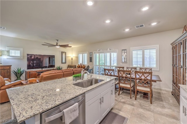 9229 Brayden Bay St, Las Vegas, NV 89178 - kitchen with stainless steel dishwasher, a sink, open floor plan, white cabinetry, and recessed lighting