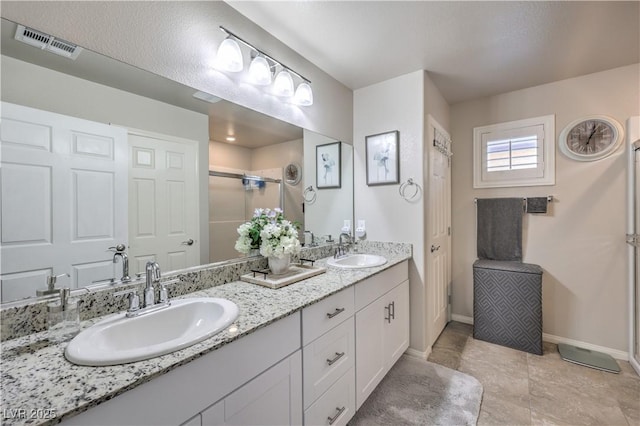 9229 Brayden Bay St, Las Vegas, NV 89178 - full bath with double vanity, a stall shower, baseboards, and tile patterned floors