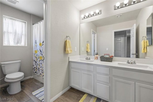 6783 Pleasant Flower St, Las Vegas, NV 89149 - bathroom with wood finished floors, toilet, double vanity, and baseboards