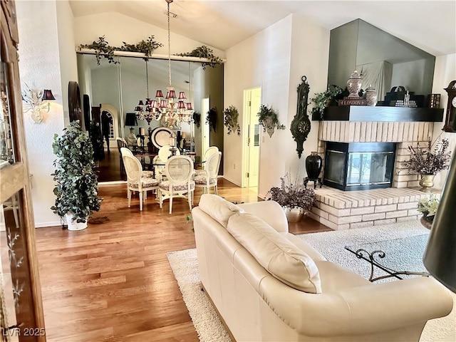 2820 Bluff Point Dr, Las Vegas, NV 89134 - living room featuring wood finished floors, vaulted ceiling, a fireplace, and a chandelier