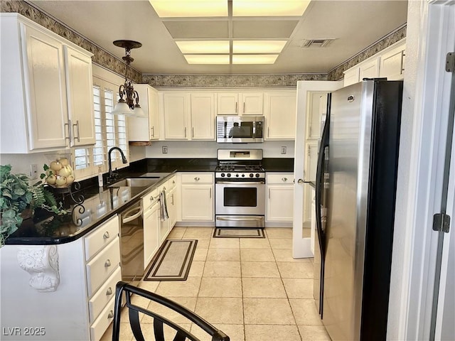 2820 Bluff Point Dr, Las Vegas, NV 89134 - kitchen with appliances with stainless steel finishes, a sink, dark countertops, and white cabinets