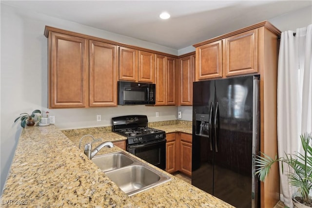 9053 Entrancing Ave, Las Vegas, NV 89149 - kitchen with black appliances, a sink, recessed lighting, brown cabinetry, and light stone counters