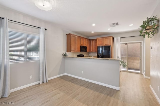 9053 Entrancing Ave, Las Vegas, NV 89149 - kitchen featuring black appliances, light wood-type flooring, baseboards, recessed lighting, and brown cabinetry
