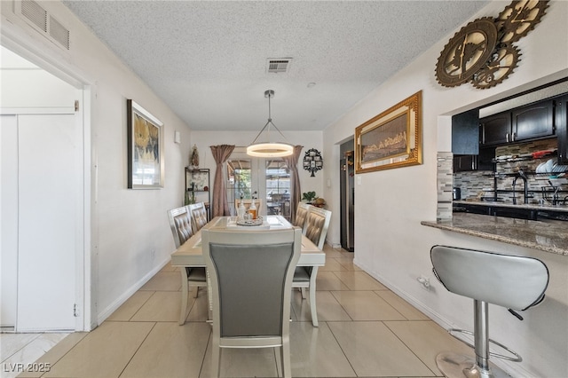 1916 Canosa Ave, Las Vegas, NV 89104 - dining space with a textured ceiling, baseboards, and light tile patterned floors