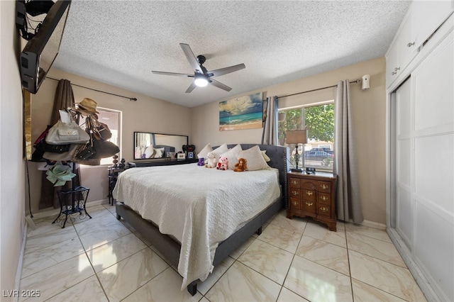 1916 Canosa Ave, Las Vegas, NV 89104 - bedroom featuring light marble finish flooring, a textured ceiling, a ceiling fan, and baseboards