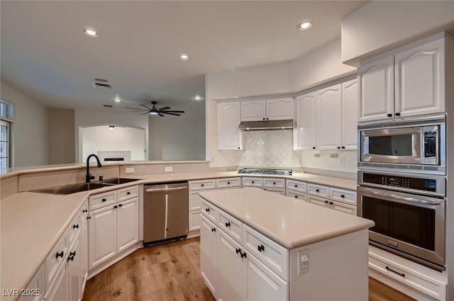 2448 Ram Crossing Way, Henderson, NV 89074 - kitchen with stainless steel appliances, under cabinet range hood, ceiling fan, a sink, and white cabinetry