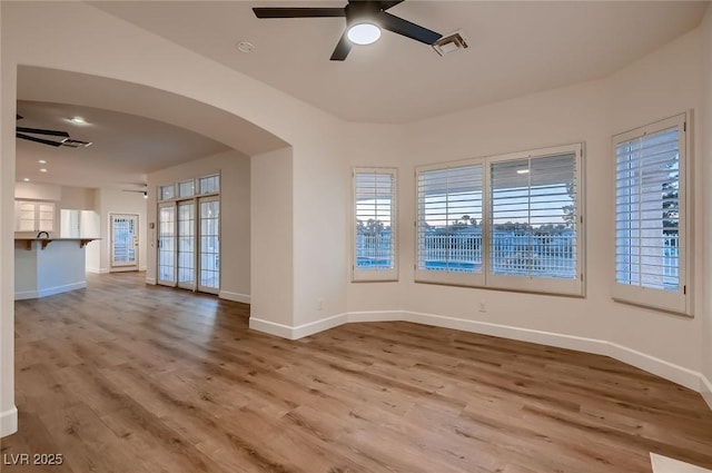 2448 Ram Crossing Way, Henderson, NV 89074 - empty room featuring ceiling fan, arched walkways, wood finished floors, and baseboards