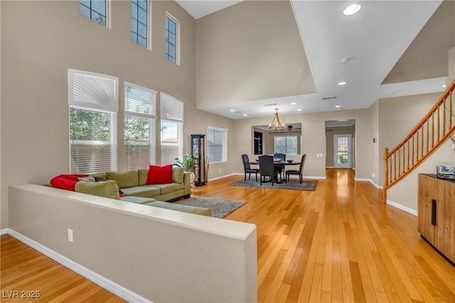 2529 Flodden St, Henderson, NV 89044 - living room featuring stairs, baseboards, light wood-style floors, a towering ceiling, and recessed lighting