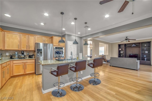 2529 Flodden St, Henderson, NV 89044 - kitchen featuring ceiling fan, stainless steel appliances, light wood-type flooring, a breakfast bar area, and open floor plan