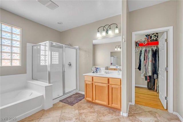 2529 Flodden St, Henderson, NV 89044 - full bathroom with a stall shower, vanity, a garden tub, a walk in closet, and baseboards