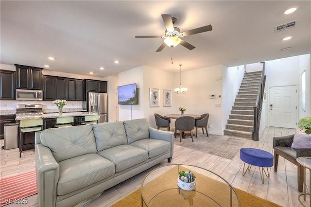 12286 Silvana St, Las Vegas, NV 89141 - living area featuring stairs, ceiling fan, wood finish floors, recessed lighting, and a chandelier