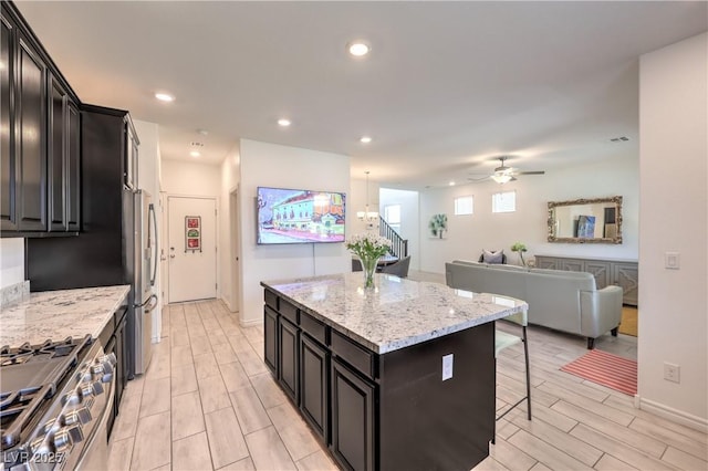12286 Silvana St, Las Vegas, NV 89141 - kitchen featuring stainless steel appliances, a breakfast bar, a center island, a ceiling fan, and open floor plan