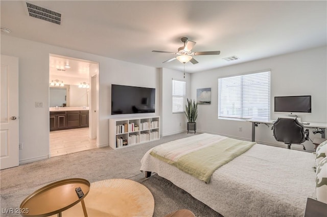 12286 Silvana St, Las Vegas, NV 89141 - bedroom with light colored carpet, baseboards, a ceiling fan, and connected bathroom