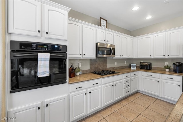 820 Colina Alta Pl, Las Vegas, NV 89138 - kitchen with black appliances, light tile patterned flooring, white cabinetry, recessed lighting, and light stone counters