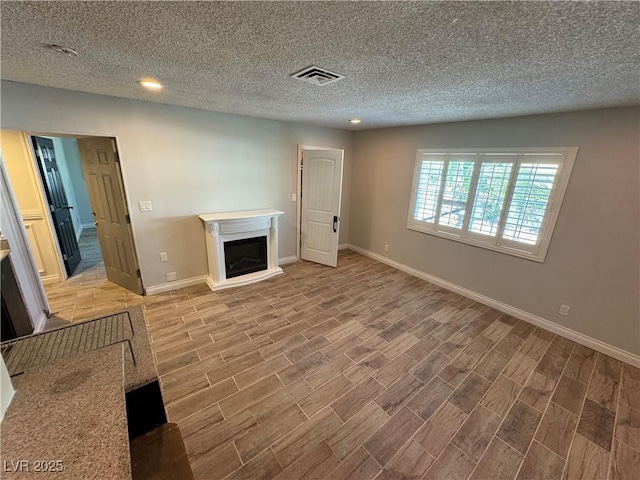 1819 Beverly Way, Las Vegas, NV 89104 - unfurnished living room featuring a fireplace with raised hearth, wood finished floors, baseboards, a textured ceiling, and recessed lighting