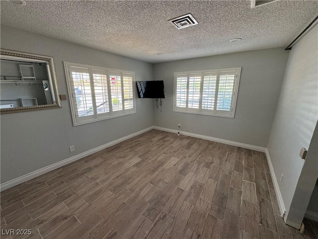 1819 Beverly Way, Las Vegas, NV 89104 - unfurnished room with wood finished floors, a textured ceiling, and baseboards